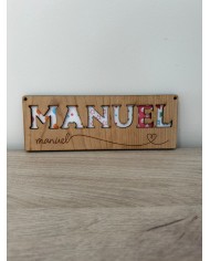 Cartel con nombre y letras troqueladas.