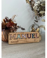 Cartel con nombre y letras troqueladas.